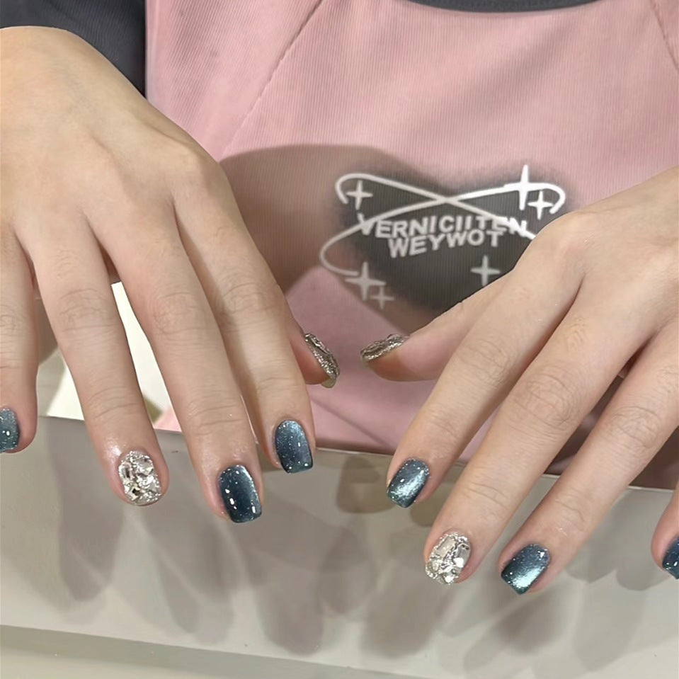 Close-up of hands with decorative nail art against a pink background with visible text.