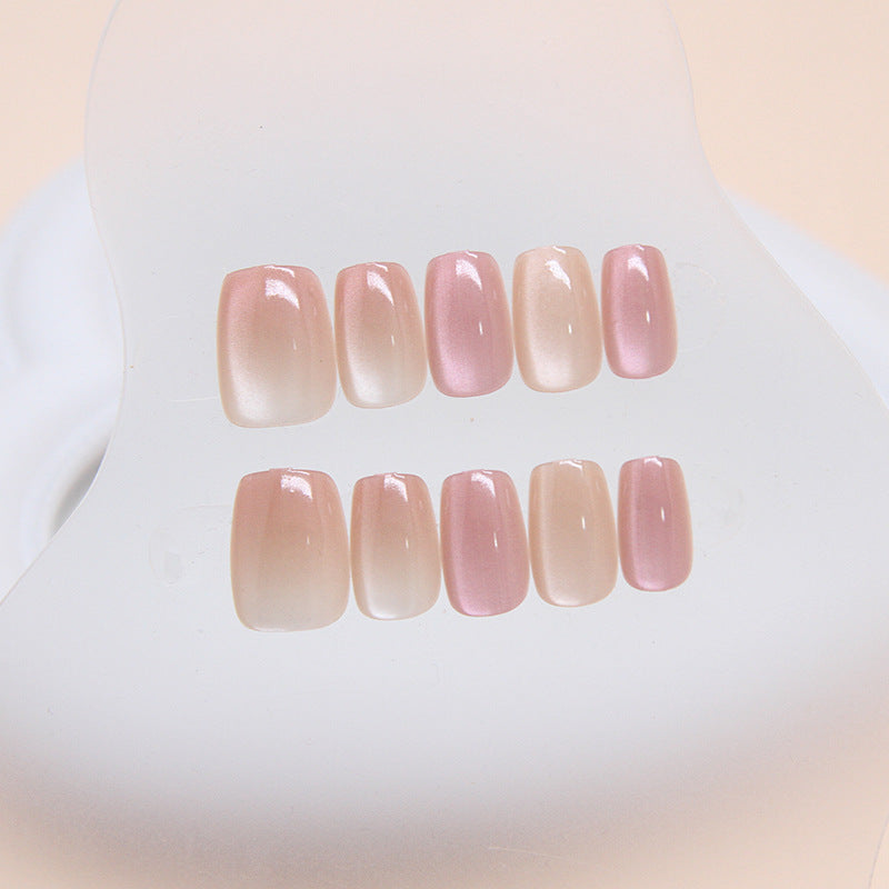 A set of press-on nails with a glossy finish, featuring a soft pink ombre color.