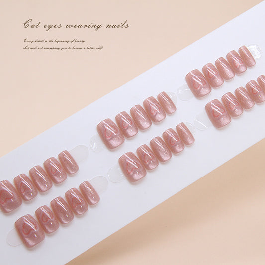 A set of pink glitter press-on nails presented in a fan-like arrangement, showcasing the short square shape and shimmer finish.