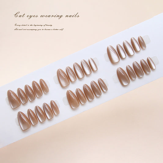 Set of brown nail extensions on a white tray with a beige background