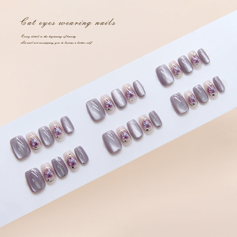 Set of gray cat-eye nail designs on a white tray with a beige background