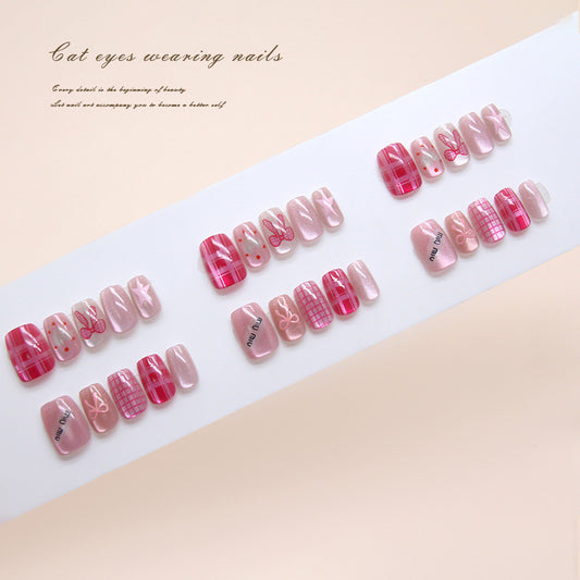 Set of pink and red nail designs on a white tray with a beige background