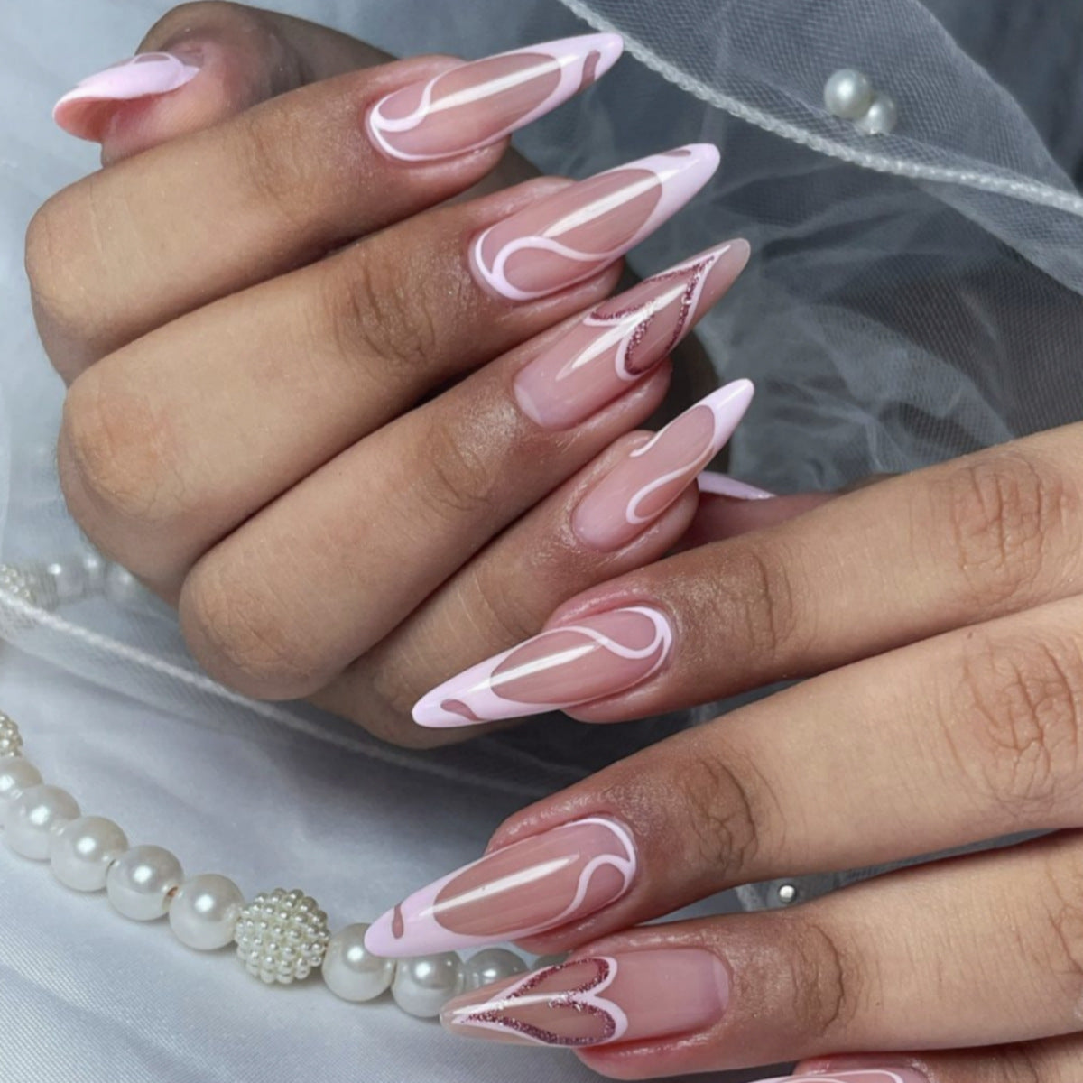 Chic Elegance Long Almond Pink Press On Nail Set with Abstract White Design and Glitter Accents