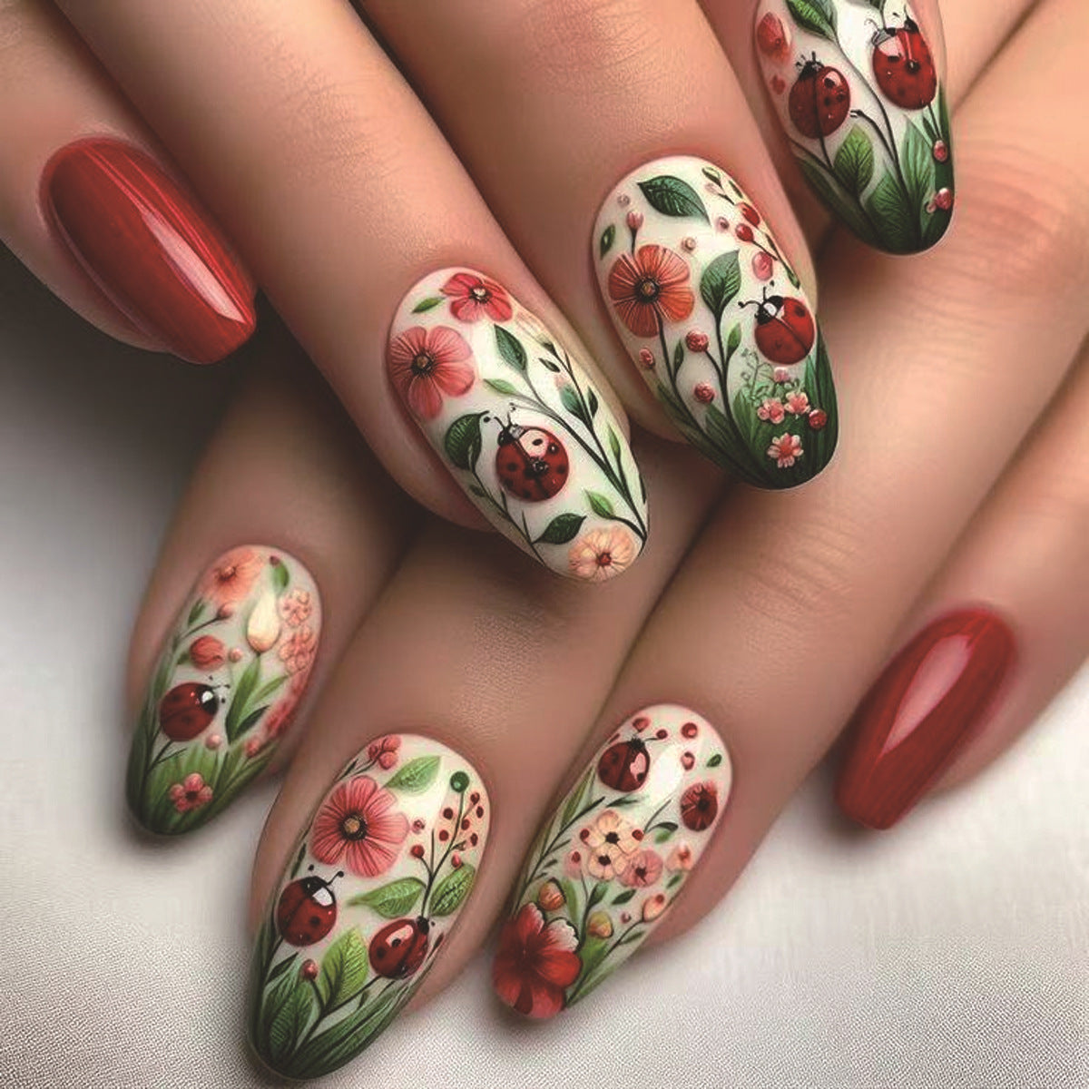 Nails with floral and ladybug designs on a light background