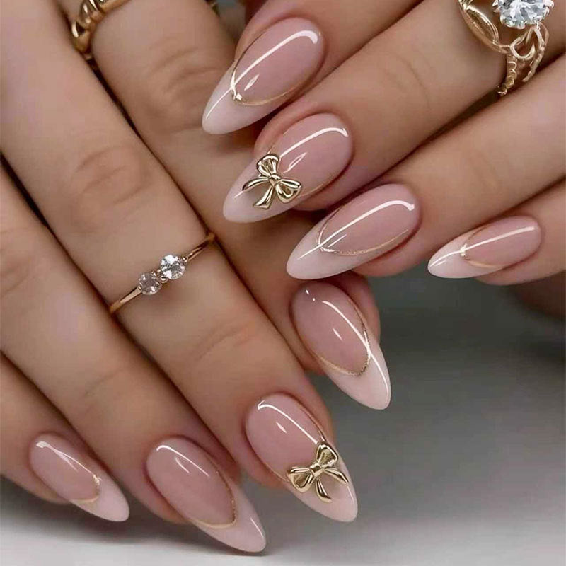 Charming Elegance Long Almond Pink Nails with Gold Accents and Unique Bow Design