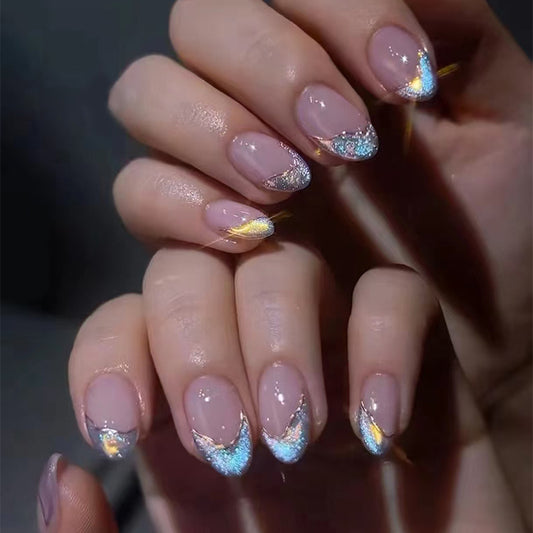 A set of medium-sized, almond pink ombre press-on nails with iridescent glitter tips.