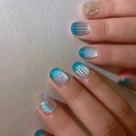 Hand with blue and silver gradient nail polish on a white background