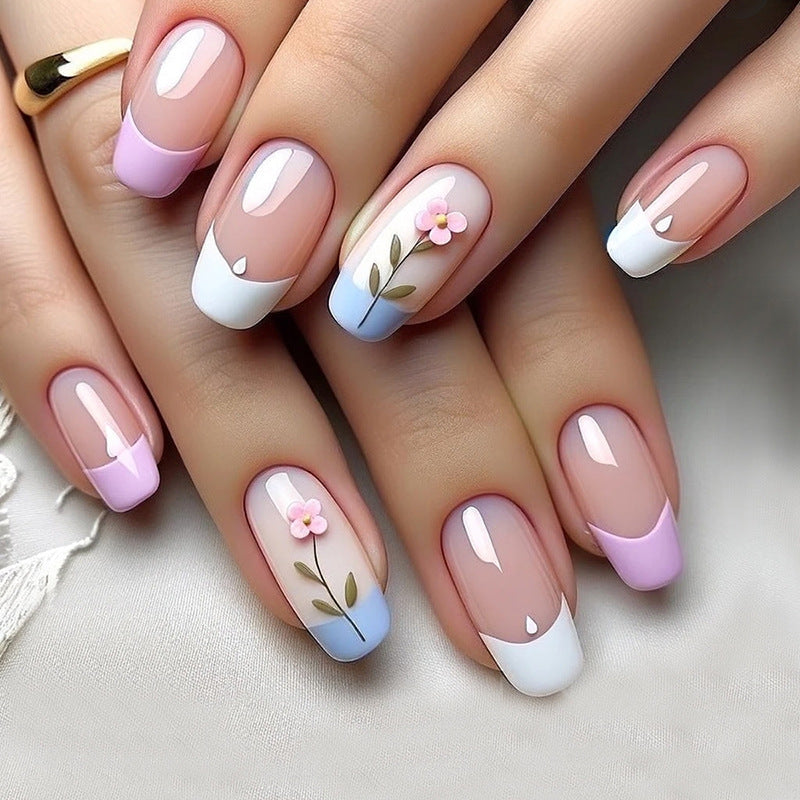 A set of press-on nails featuring a floral design with pastel pink, blue, and white colors.