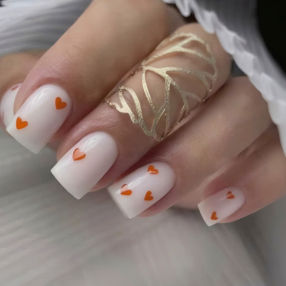 Charming Love Theme Medium Square White Nail Set with Bright Orange Heart Accents for a Playful Touch