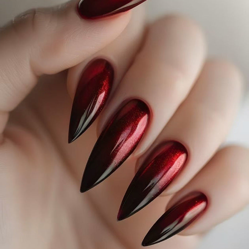 Close-up of a hand with red and black nail polish on a neutral background