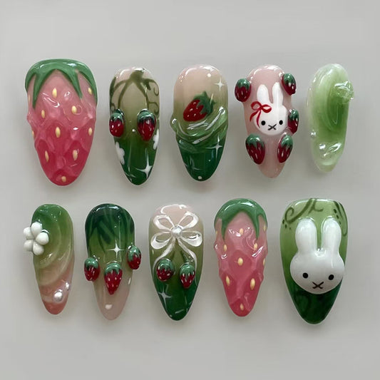 Whimsical Garden Press On Nail Set in Medium Almond Shape with Pastel Pink and Green Colors Featuring Adorable Bunny and Strawberry Designs