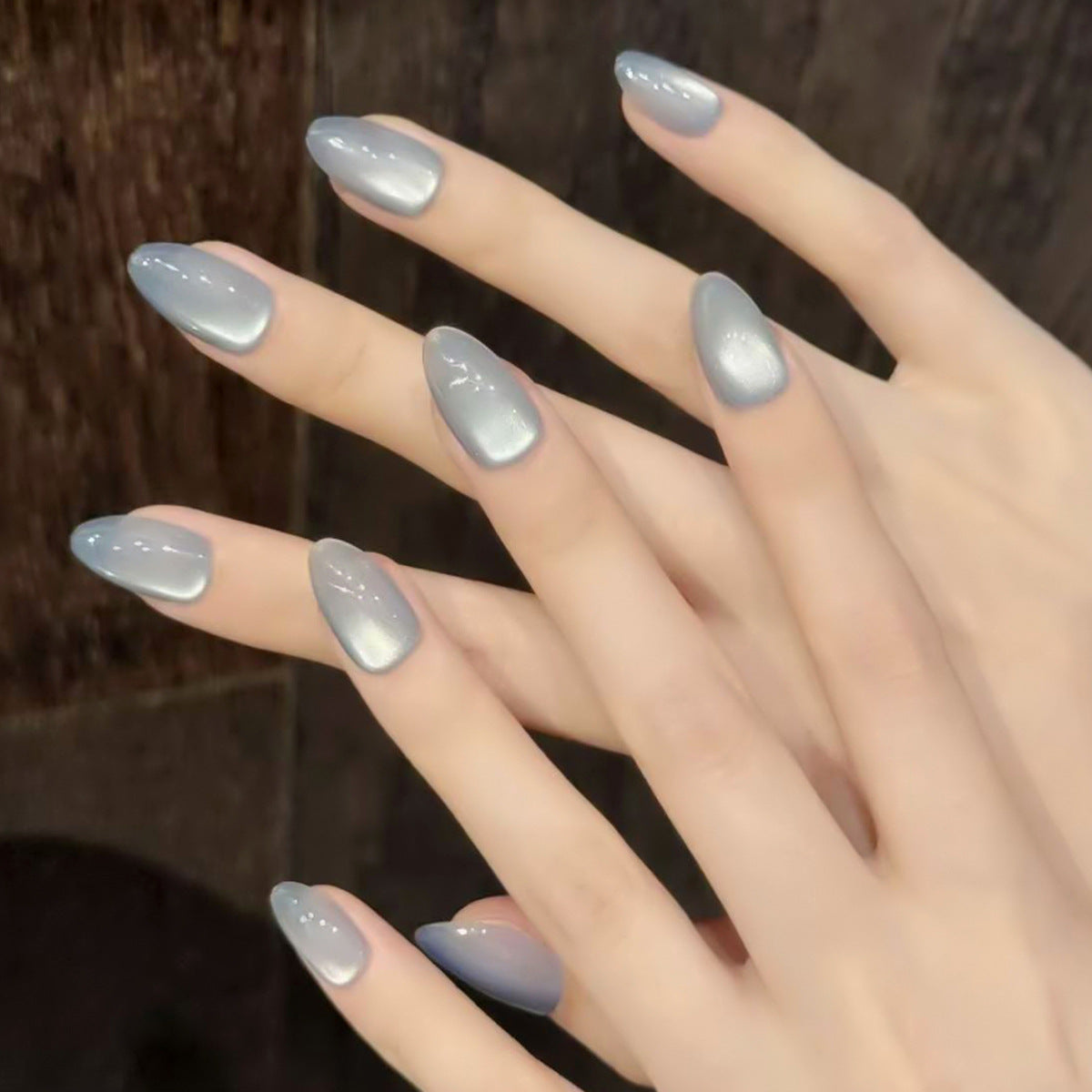 Hand with light blue nail polish on a blurred background