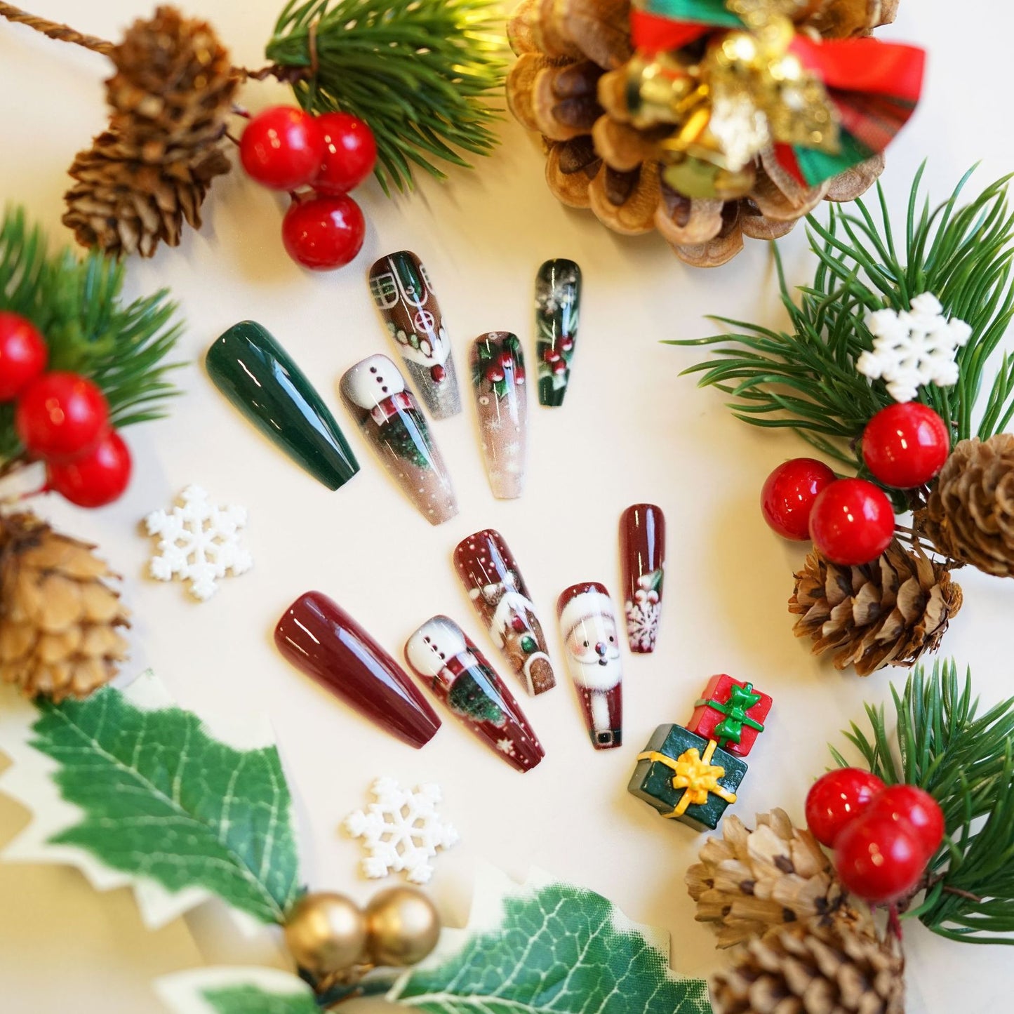 Christmas-themed nail art designs on a decorative background with pine cones and berries.