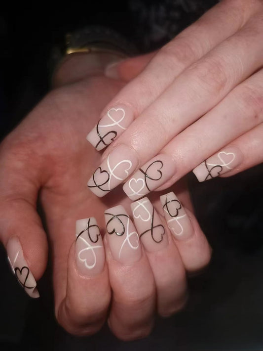 Charming Romance Extra Long Coffin Press On Nail Set in Beige with Black Heart Patterns and Glossy Finish