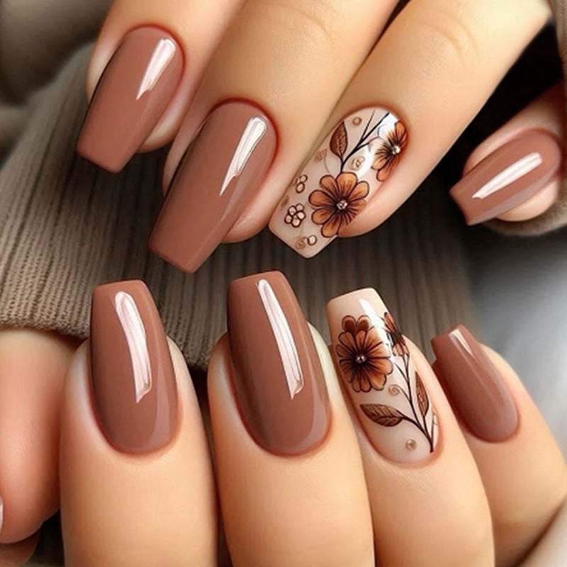 A set of press-on nails featuring a floral design with brown and beige colors.