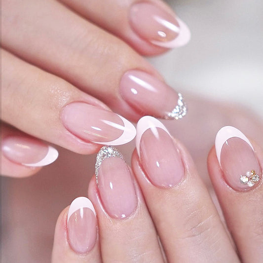 A set of short almond-shaped press-on nails with pink and white color and glitter accents.