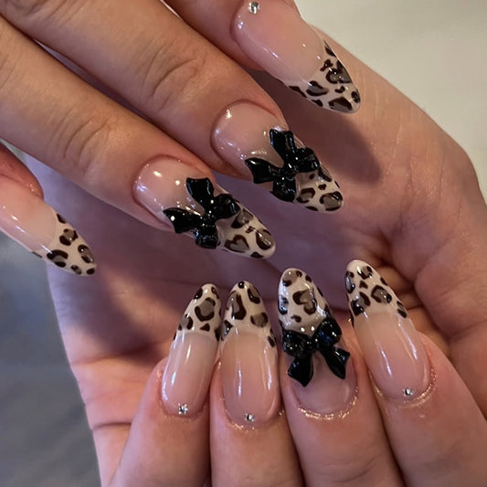 Wild Chic Medium Almond Shaped Elegant Beige and Brown Leopard Print Press On Nail Set with Charming Black Bows and Shimmering Accents