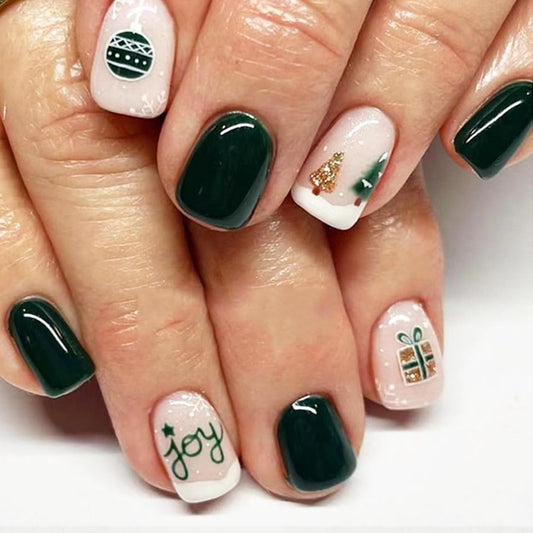A set of press-on nails featuring a green base with short square shapes, Christmas designs, and the word 'joy' displayed on a white surface.