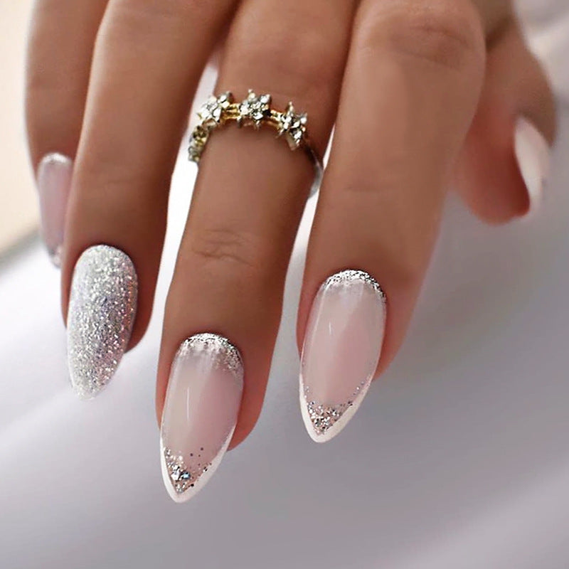 Close-up of a hand with pink and silver glittery nails on a neutral background