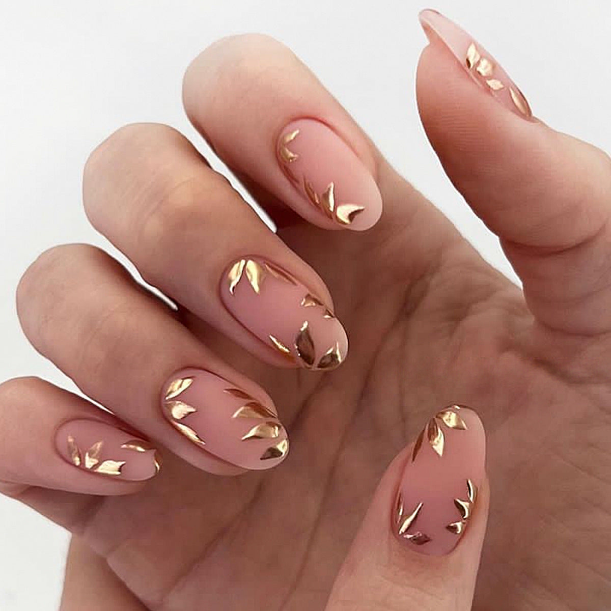 Nails with pink and gold design on a white background
