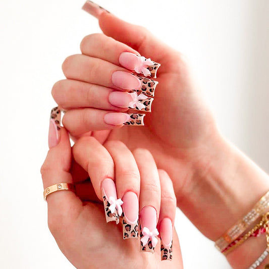 Nail art display with pink and leopard print designs on a white background