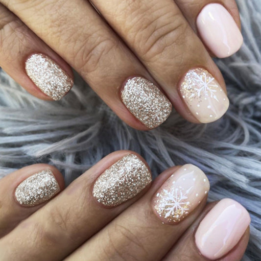 Close-up of hands with glittery and pink nail designs on a textured gray background