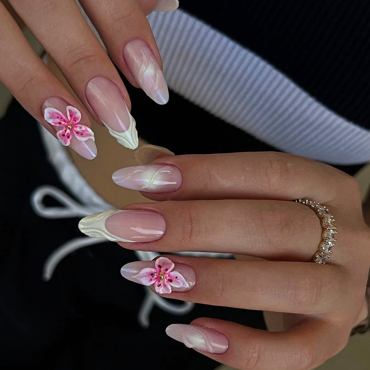Close-up of hands with pink floral nail art on a blurred background