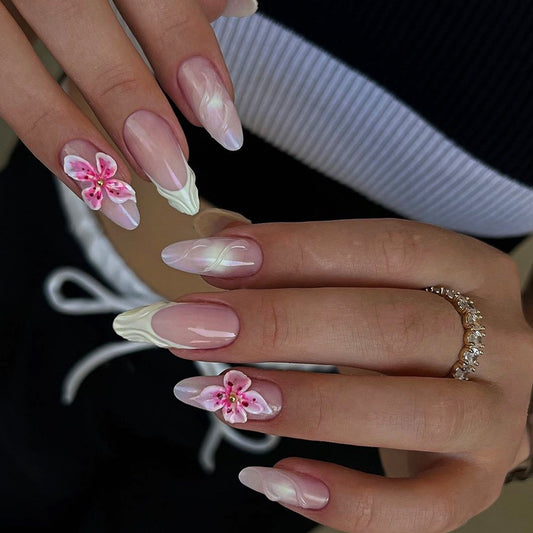 Close-up of hands with pink floral nail art on a blurred background