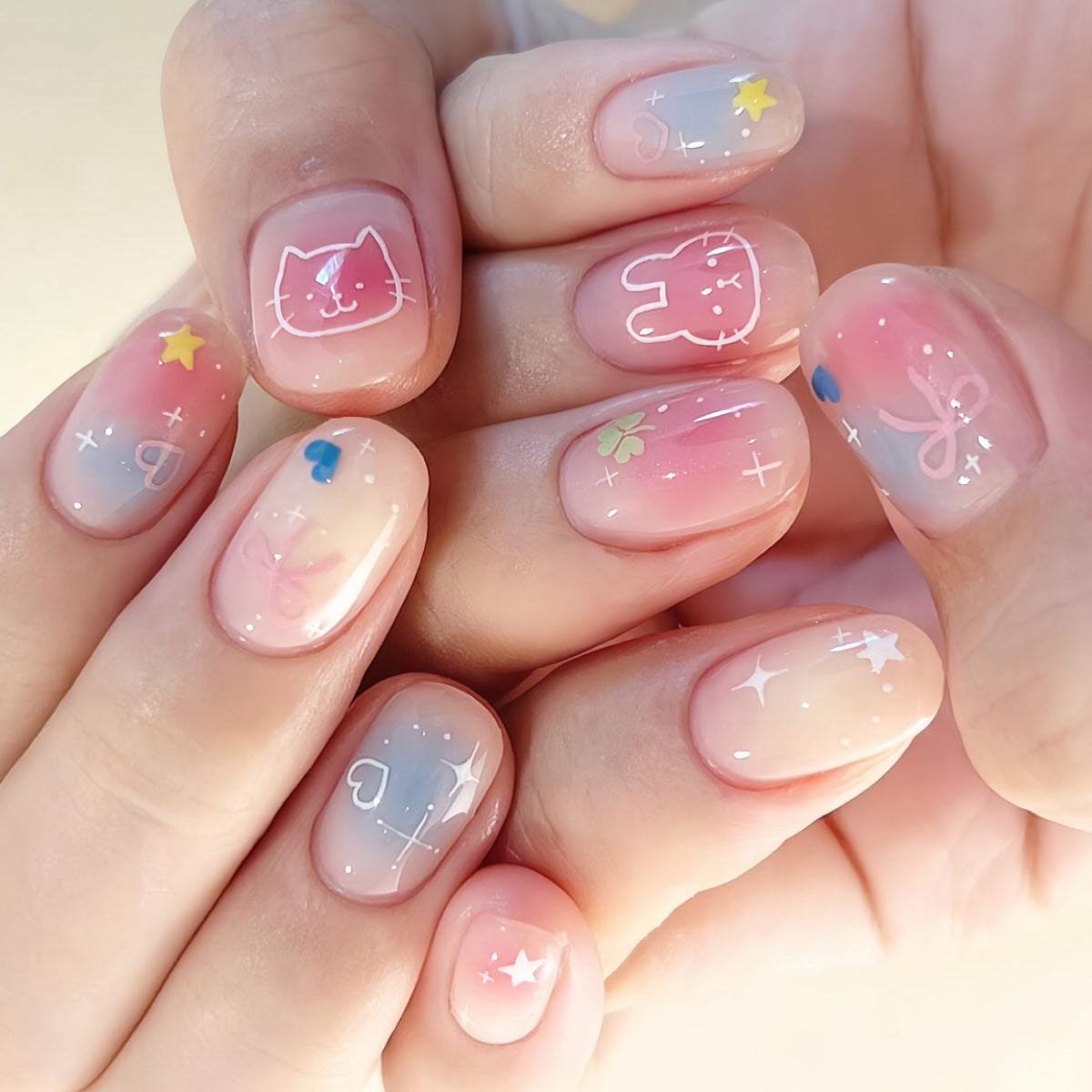 Dreamy Whimsy Press Nail Set in Short Length Squoval Shape with Pink to Blue Ombre Gradient and Adorable Cartoon Characters