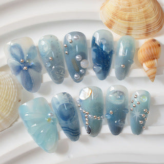 Ocean Breeze Inspired Long Almond Shaped Blue Nail Set with Floral Accents and Pearl Detailing