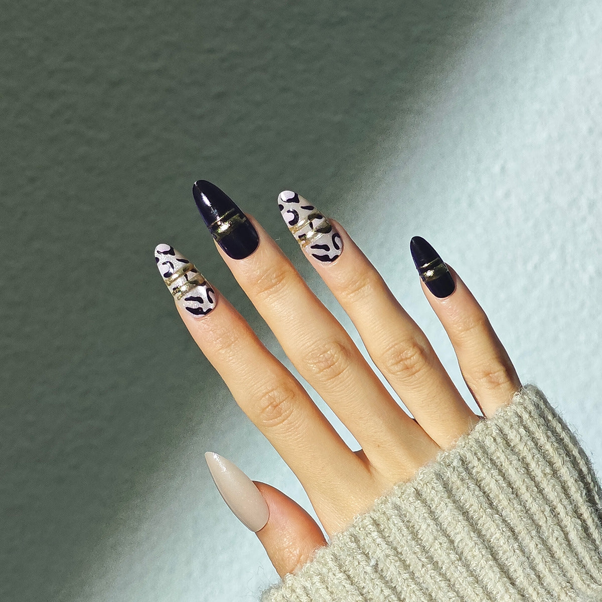 Nails with black and white patterned design against a neutral background