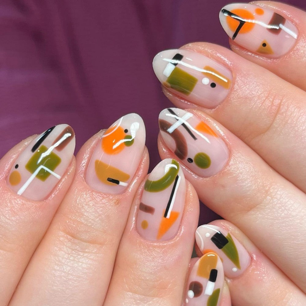 A set of press-on nails featuring geometric abstract designs in beige, orange, and green shades.
