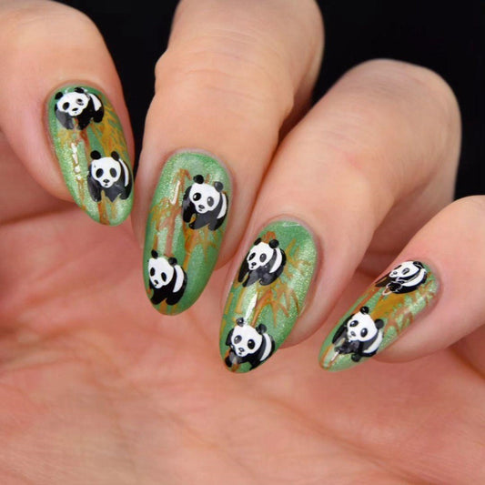 A set of press-on nails with a green background and cute panda designs.