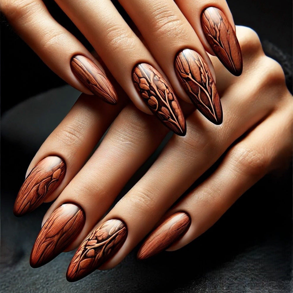 A set of press-on nails featuring an almond brown woodgrain design with floral detailing.