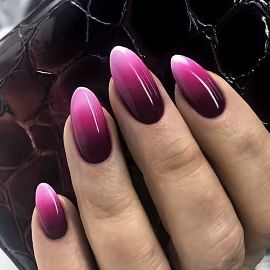 A set of long almond-shaped press-on nails with a pink to purple gradient glossy finish.
