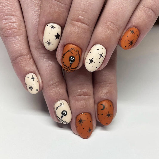 Spooky Halloween Oval Length Matte Orange and Cream Press On Medium Nail Set with Skull and Star Patterns