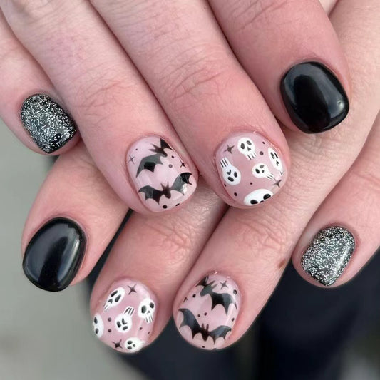 Spooky Halloween Themed Short Oval Black and Pink Nails with Bats and Skulls Design