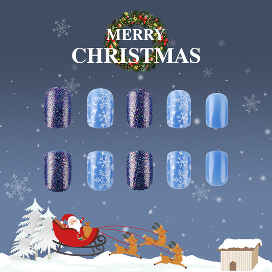 A set of press-on nails with a winter wonderland theme, featuring a combination of blue and glittery designs, displayed alongside a 'Merry Christmas' message.