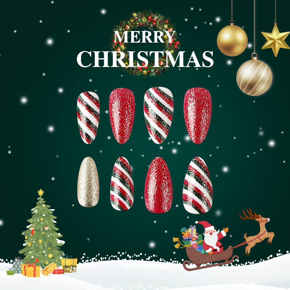A set of press-on nails featuring a festive design with red glitter and gold stripes, displayed alongside a Christmas-themed backdrop with holiday decorations.