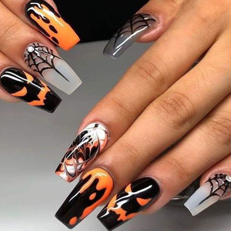 A set of long press-on nails featuring a Halloween-themed design with black, orange, and gray colors, and a spiderweb pattern.