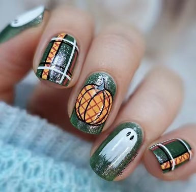 A set of press-on nails featuring a design with green, orange, and white colors, and a pumpkin and ghost motif.