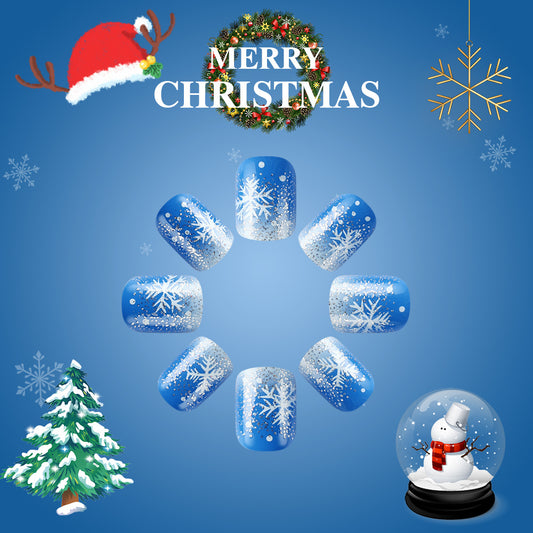 A set of blue short squoval nails with a glittering snowflake design, displayed with a 'Merry Christmas' message and festive decorations around.