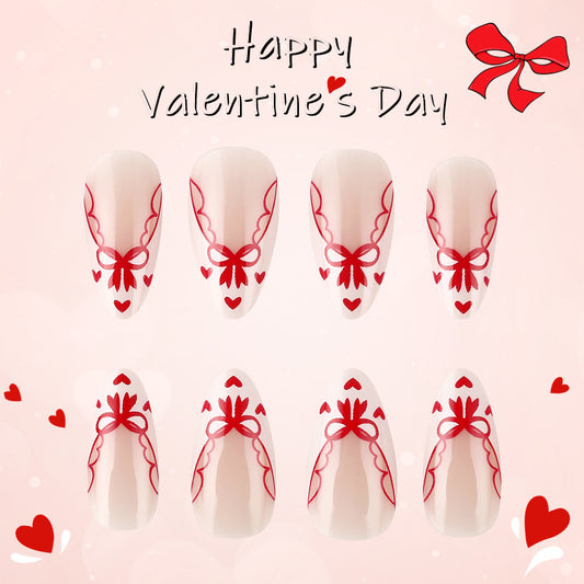 A set of artificial nails in medium almond shape with a soft pink base and red bow designs, displayed against a Valentine's Day themed background.