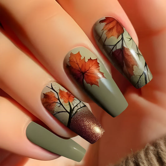 A set of long, olive green press-on nails with a leaf design, featuring a combination of fall colors.