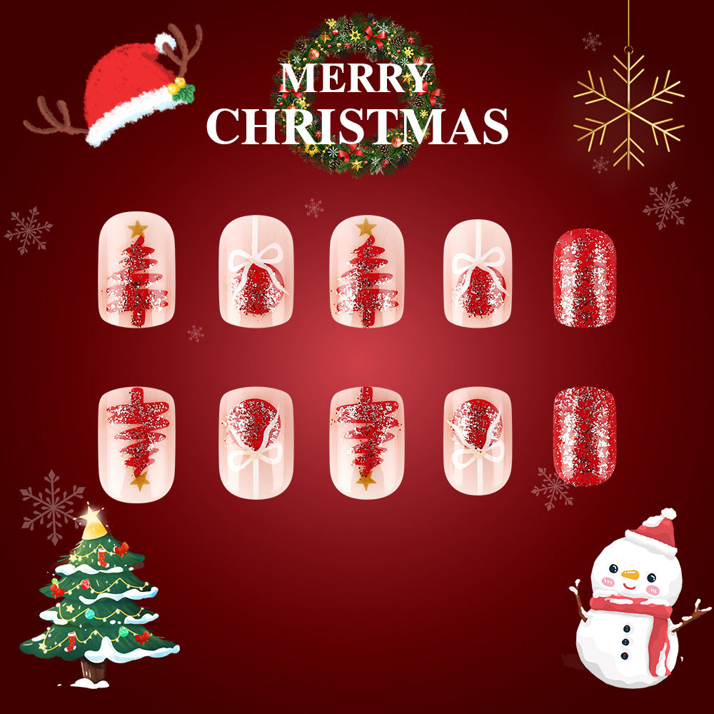A set of short square red glittering nails with Christmas designs, displayed against a festive background with a Christmas tree and snowman.