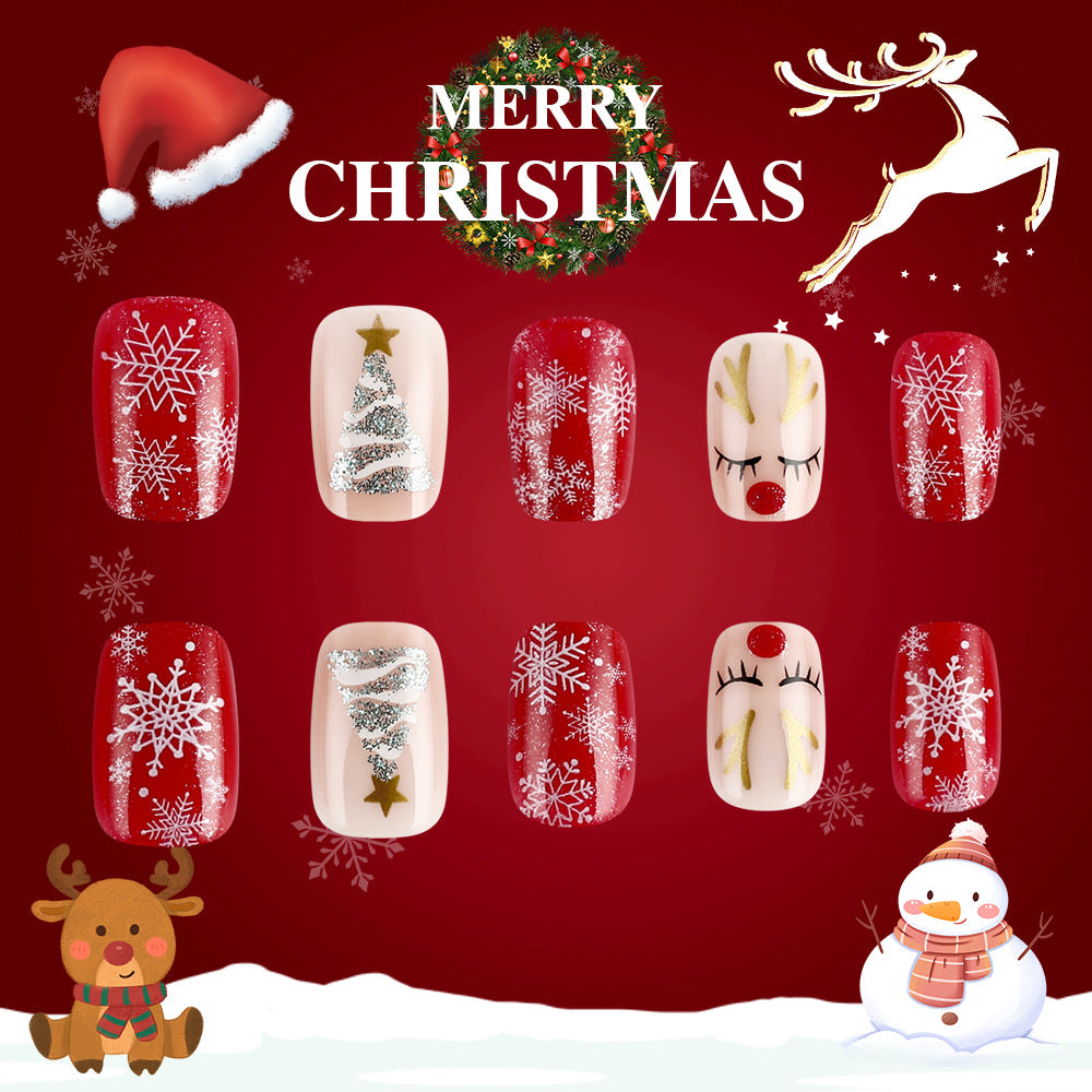 A set of red oval nails with glittering snowflake and reindeer designs, displayed against a festive Christmas themed background.