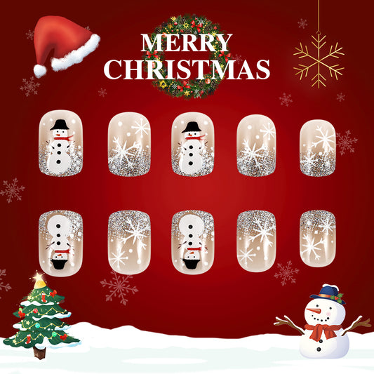 A set of press-on nails featuring a Christmas-themed design with snowman motifs in clear, white, and glitter finishes, displayed against a festive red background with snow and a Christmas tree.