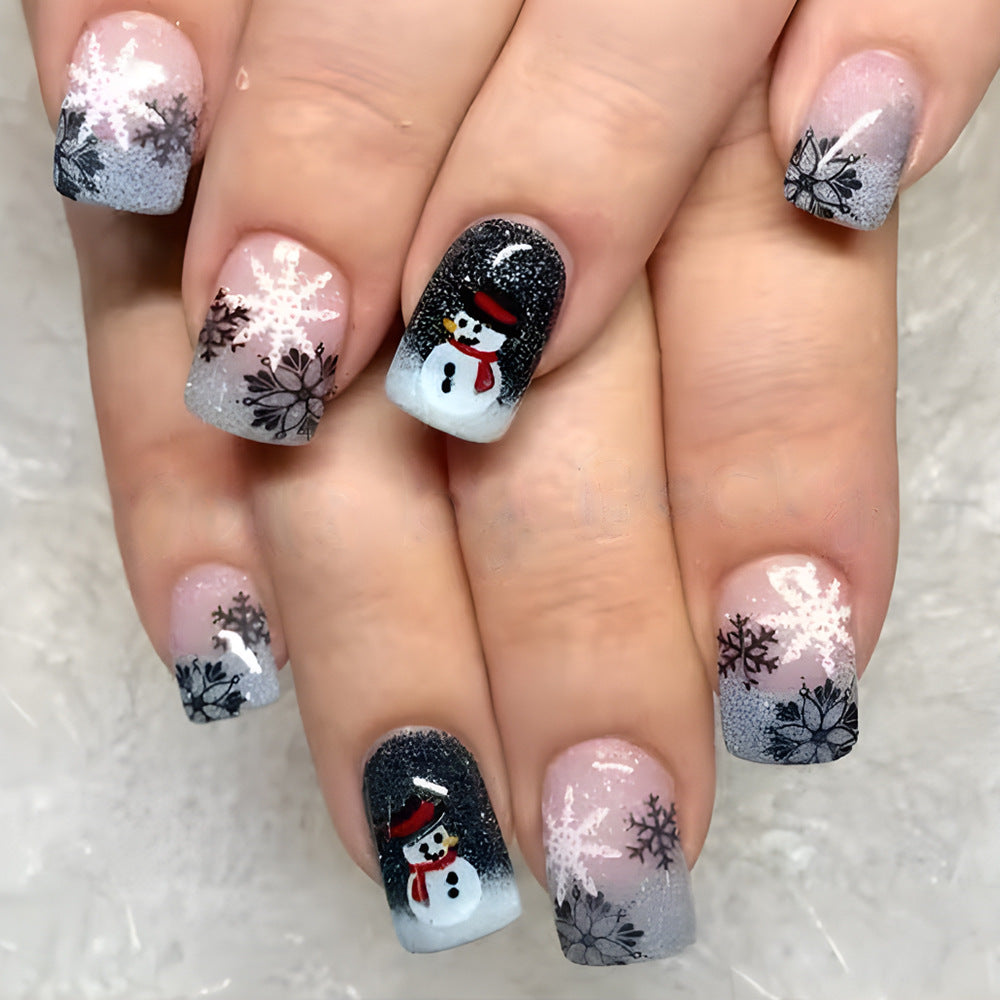 Nails with winter-themed designs including snowflakes and snowmen on a light background