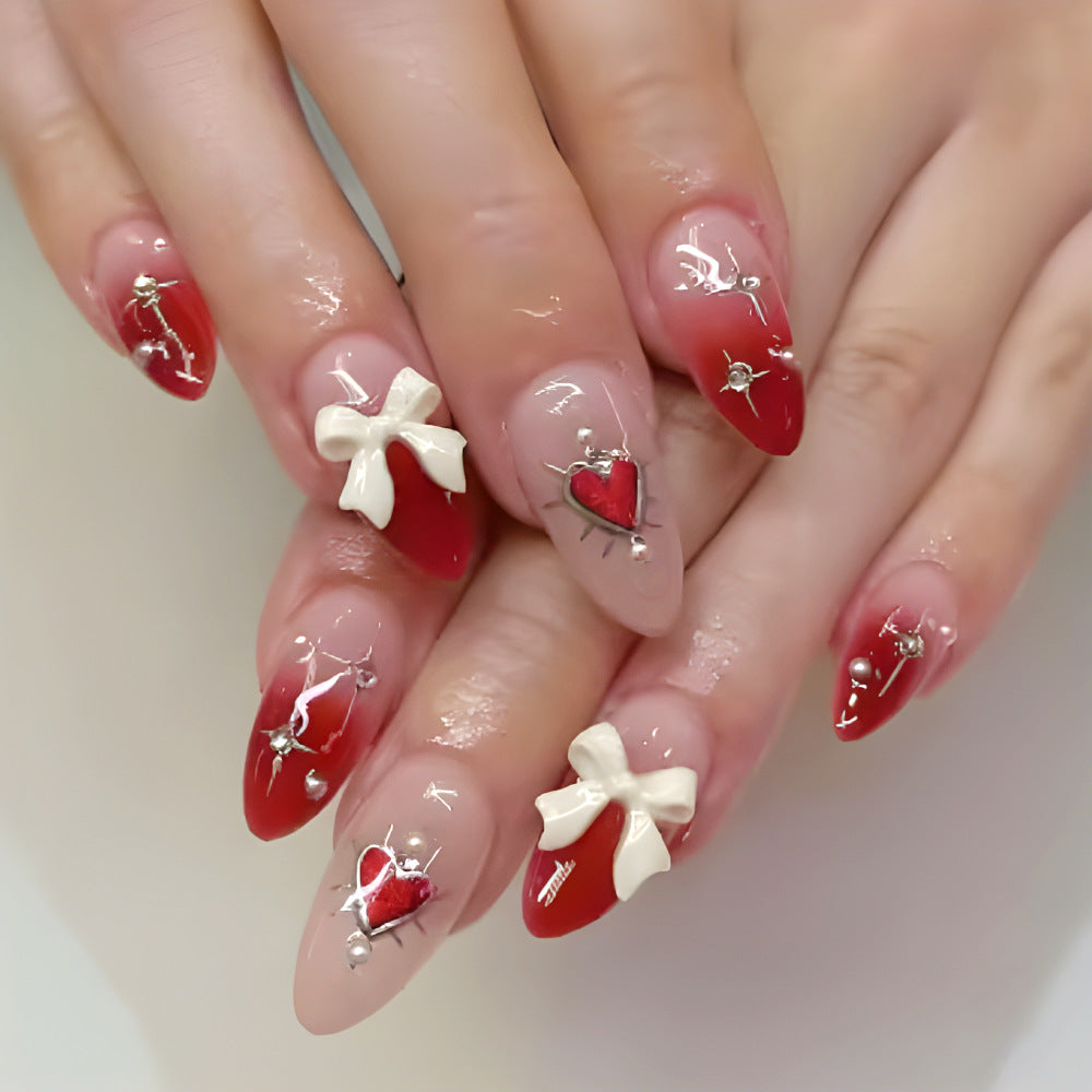 Nails with red and white designs on a neutral background
