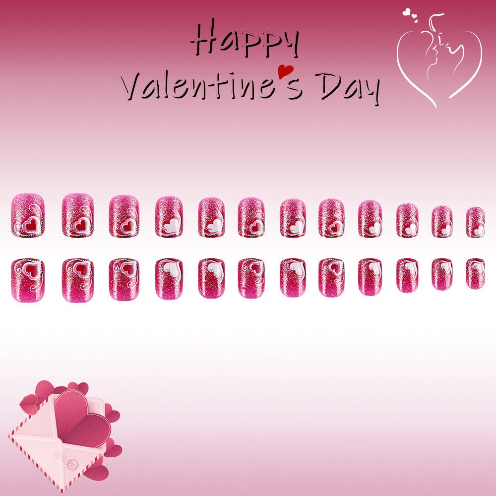 Valentine's Day-themed nail art design with pink hearts on a pink background.